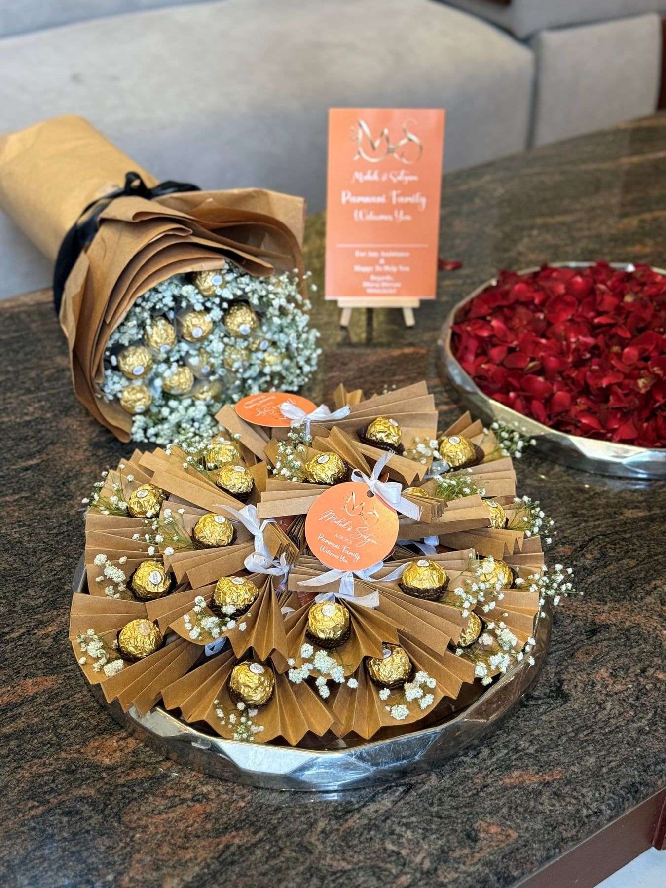Kraft paper bouquet with baby's breath and a tray of Ferrero Rocher arranged in kraft paper fans with peach tags